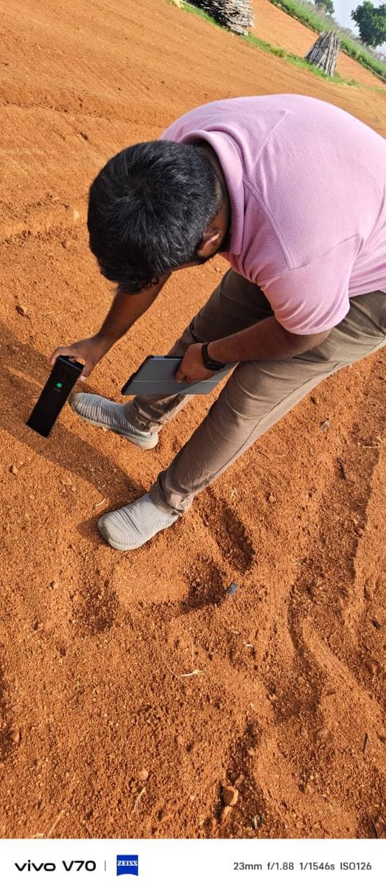 Field operator testing prepared soil with Soilo Essence while holding a tablet